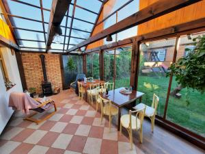 a conservatory with tables and chairs and windows at Stajnia Bukwica in Narewka