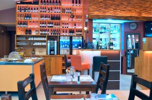a restaurant with tables and chairs and a bar at FH Confort Hotel Orléans Co'met in Orléans