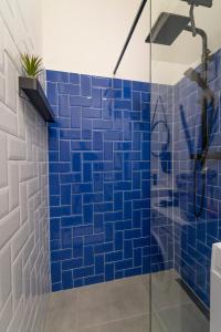 een blauwe betegelde badkamer met een douche bij Adele I levestate in Wenen