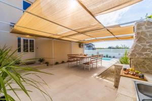 a patio with a wooden pergola and a table at Villa Ostone in Pula