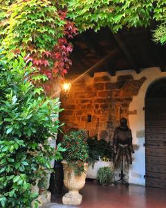 une statue dans une cour agrémentée de plantes dans l'établissement Torre de Salis, à Gussago