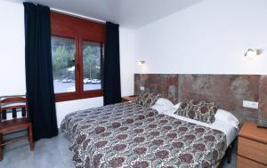 Llit o llits en una habitació de Hotel Comapedrosa