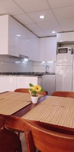 cocina con 2 mesas de madera y nevera en Apartamento Lauren Salou, en Salou