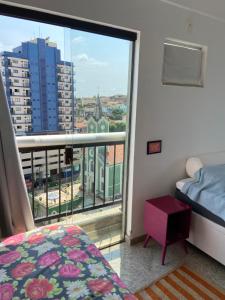 a bedroom with a bed and a view of a city at Lindo apartamento em Caxambu in Caxambu