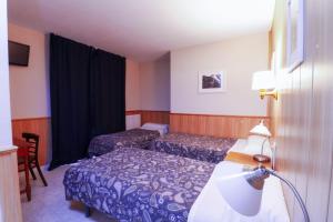 a hotel room with two beds and a lamp at Hotel Comapedrosa in Arinsal