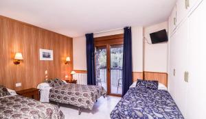 Llit o llits en una habitació de Hotel Comapedrosa