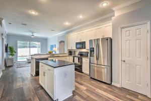 a kitchen with white cabinets and a stainless steel refrigerator at Apopka Single-Story Home with Private Lanai and Pool! in Orlando
