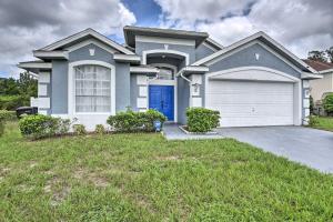 a house with a blue door and a garage at Apopka Single-Story Home with Private Lanai and Pool! in Orlando