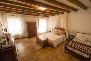 1 dormitorio con cama, mesa y ventanas en SAN LUCA 1836, en Venecia
