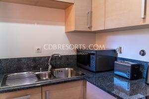 eine Küche mit einer Spüle und einer Mikrowelle in der Unterkunft Baia da Luz Resort in Luz