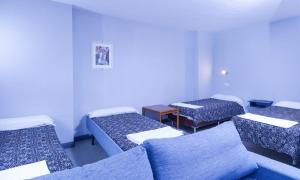 a hotel room with two beds and a couch at Apartaments Crest Pas in Pas de la Casa