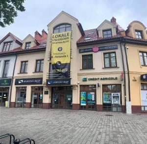 a large building with a sign on the side of it at Apartament Centrum Mazury - Szczytno in Szczytno