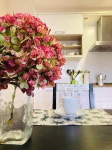a vase filled with pink flowers sitting on a table at CASA DE AREAS in Sanxenxo +58 photos