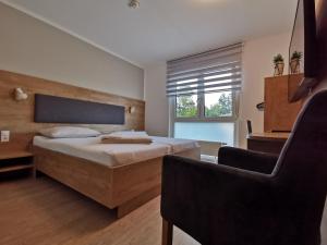a bedroom with a bed and a chair at Motel Hohenems in Hohenems