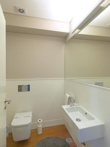 a bathroom with a sink and a toilet and a mirror at FLH New Oporto Apartments - São Bento in Porto