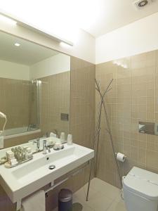 a bathroom with a sink and a toilet and a mirror at FLH New Oporto Apartments - São Bento in Porto