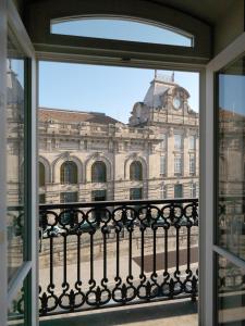 una finestra con vista su un edificio con torre dell'orologio. di New Oporto Apartments - São Bento a Porto