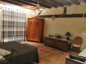a room with a bed and a cabinet and a table at Le clos des augers, chambres d'hôtes et roulotte in Azay-sur-Cher