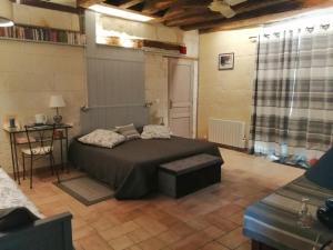 a bedroom with a bed and a table in it at Le clos des augers, chambres d'hôtes et roulotte in Azay-sur-Cher