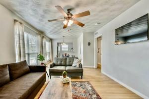 un soggiorno con divano e ventilatore a soffitto di The Swank • Close to Downtown a Dallas