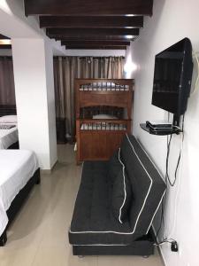 a bedroom with a bed and a tv and a couch at Apartamento Edificio Bahía Fragata in San Andrés +17 photos
