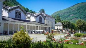 a large white building with flowers in front of it at La Pépite in Luchon