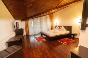 a bedroom with a bed and a couch in a room at Casa Frent in Predeal