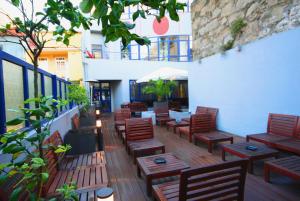 eine Terrasse mit Holztischen und -stühlen auf einem Gebäude in der Unterkunft PILOT Design Hostel & Bar in Porto
