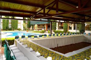 a patio with chairs and a swimming pool at Hotel & Suites Villa del Sol in Morelia
