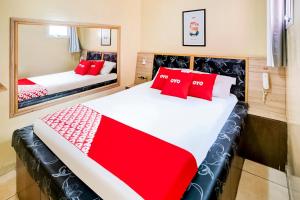 聖保羅的住宿－OYO Hotel Itarantim, São Paulo，一间卧室配有两张带红色枕头的床