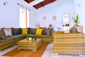 a living room with a couch and wicker furniture at Villa Sunrise in Deshaies