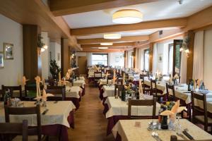 una sala da pranzo con tavoli e sedie di Hotel Rio a Caderzone