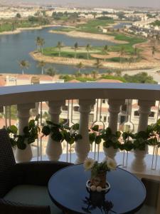 a balcony with white columns and a table with flowers at Furnished studio in Al Hamra village with Lagoon view in RAK in Ras al Khaimah