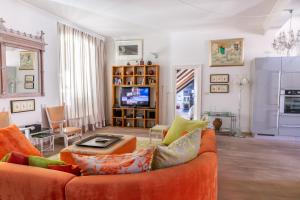 a living room with an orange couch and a tv at Dubrovnik Luxury Apartments in Dubrovnik