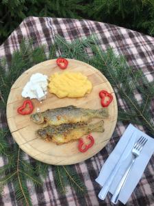 a plate of food with a fish and eggs and tomatoes at CABANA MARIA-PETRIMANU in Ciungetu +19 photos