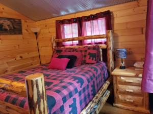 a bedroom with a bed in a log cabin at The Riverside - An Amish Built Log Cabin in Genoa