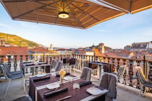 a restaurant with tables and chairs on a balcony at Prijeko Palace in Dubrovnik