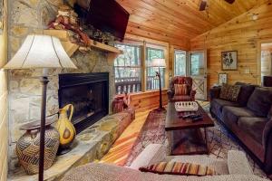 a living room with a fireplace in a log cabin at Indian Rock Lake in Blue Ridge