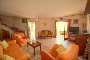 マッサ・ルブレンセにあるVilla Panoramaのリビングルーム(オレンジ色のソファ、テレビ付)