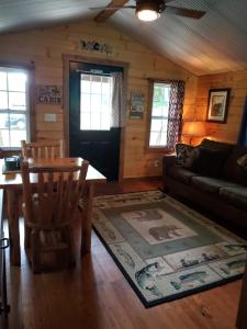 a living room with a couch and a table at The Riverside - An Amish Built Log Cabin in Genoa