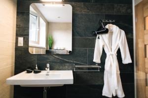 a bathroom with a white sink and a mirror at Miracle Seasons in Liptovský Mikuláš