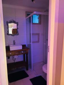 a purple bathroom with a sink and a shower at MarBella alugueis de quartos in Penha