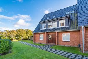 a red brick house with a blue roof at Falkennest 2 in Westerland (Sylt)