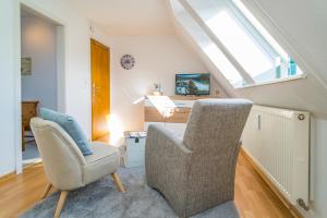 a living room with two chairs and a desk at Falkennest 2 in Westerland (Sylt) +7 photos