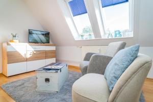 a living room with two chairs and a tv at Falkennest 2 in Westerland (Sylt)