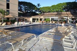 a pool with chaise lounge chairs and a resort at Aston Mahana Kaanapali Beach Resort in Lahaina