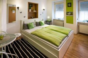 a bedroom with a large bed with a green blanket on it at Zimmer am Markt in Traben-Trarbach
