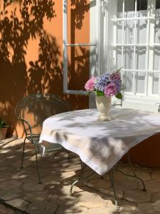 un jarrón de flores sentado en una mesa con dos sillas en Cozy Apartment in a Historic Villa, en Merano