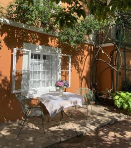 Una mesa y sillas frente a un edificio con una ventana. en Cozy Apartment in a Historic Villa, en Merano