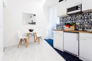 a kitchen with white cabinets and a table at LUXURY SWEET HOME FARNESE - CAMPO DEI FIORI in Rome